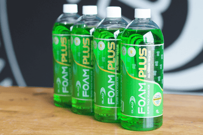 Bottles of Green 4L Heavy Duty Snow Foaming Car Wash Product "Snow Foam Plus" In Front Of a Wat-er Blast Logo