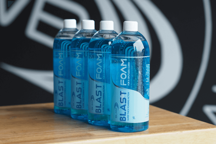 Bottles of Blue Marine Scented 4L Snow Foaming Car Wash Product Snow Foam in Front of Wat-er Blast Logo