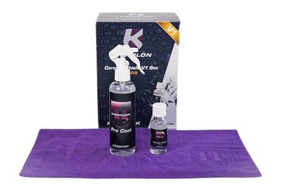 1 x 200mL Clear Bottle with Black Label Containing Kenolon 'Pre Coat' and 1x 30mL Clear Bottle with White Lid and Black Label Containing Kenolon 'Ceramic Shield'. Both Bottles are Sitting on a Purple Microfibre Towel Sitting in Front of 'Ceramic Shield V1' Box