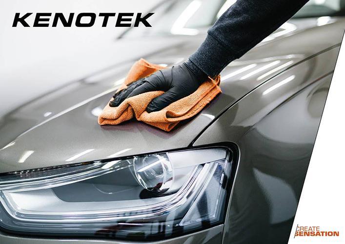 Person Wearing Black Glove Polishing a Dark Grey Car with Orange Microfibre Cloth with 'Kenotek' Printed at the Top of the Image